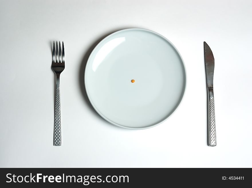 Empty white plate with knife and fork