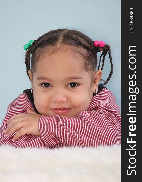 Toddler girl posed resting her chin on her arms