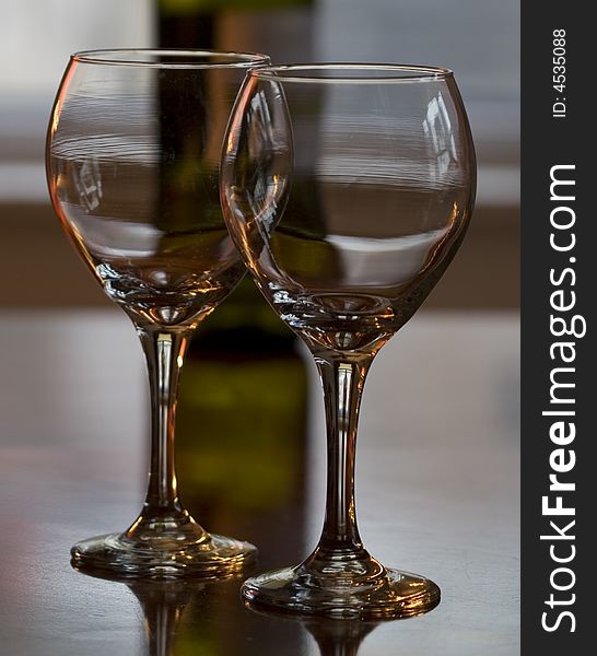 Image of two wine glasses with bottle in the background. Image of two wine glasses with bottle in the background