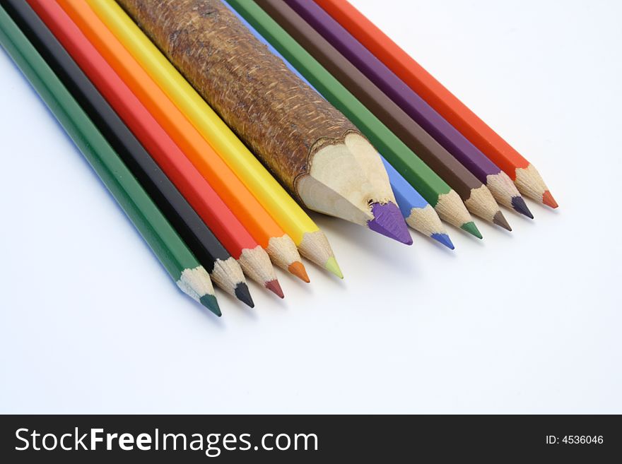 Different coloured pencils lying on white background