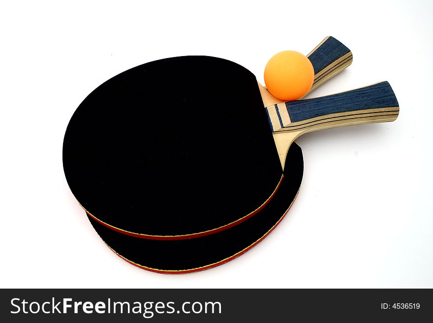 Ping pong paddles and an orange ball over a white surface