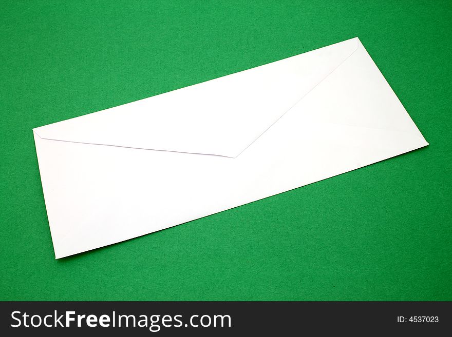 Plain white envelope over a green surface. Plain white envelope over a green surface