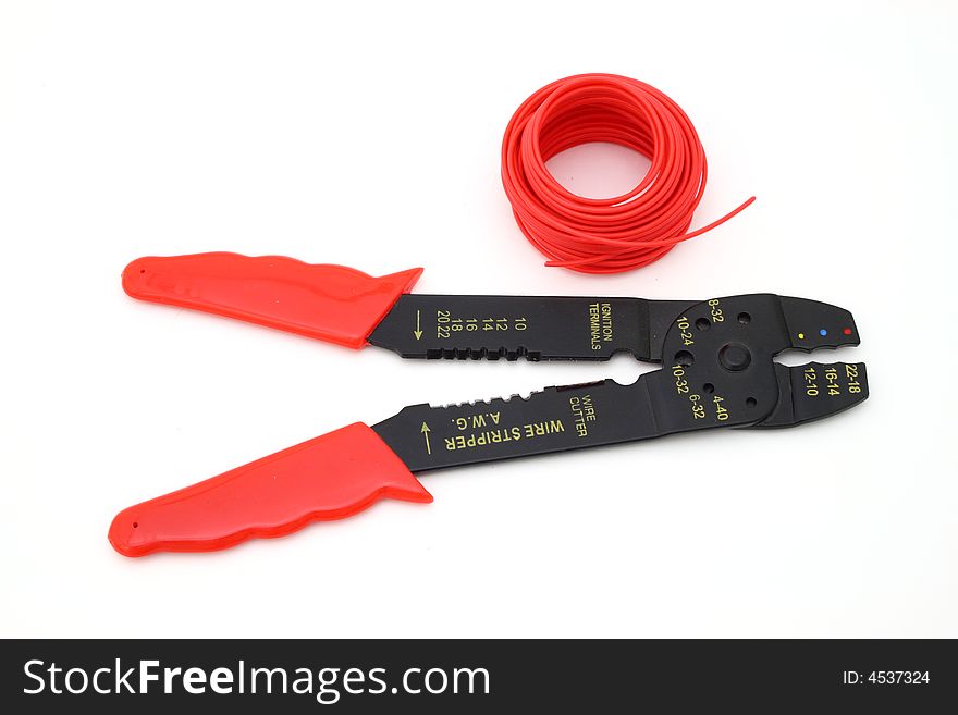 wire strippers and a spool of red wire over a white surface