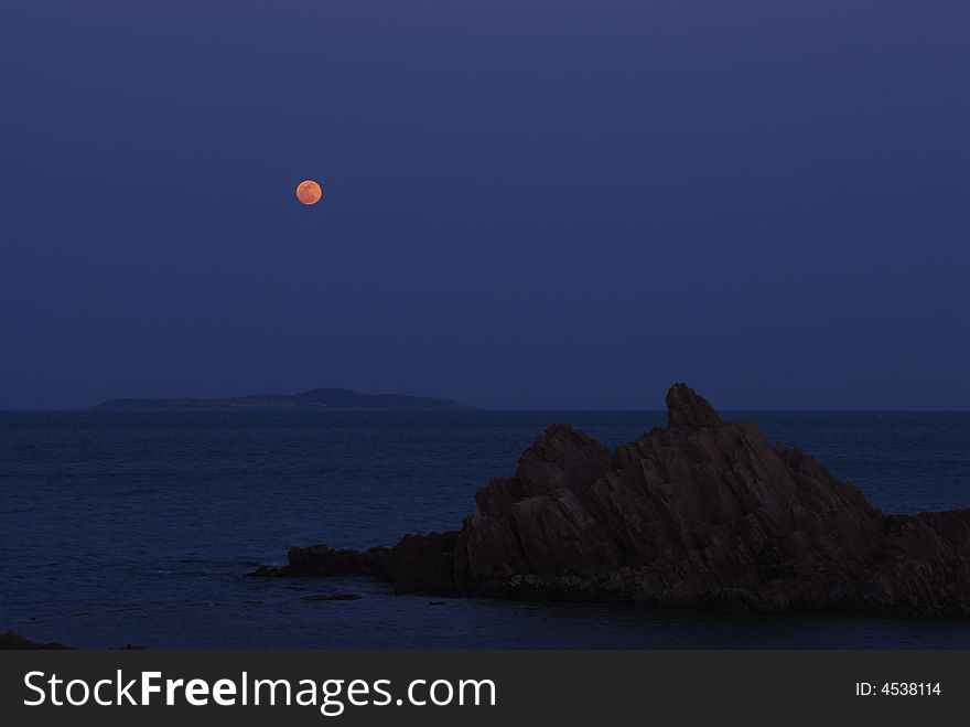 A moon rises on the sea. A moon rises on the sea