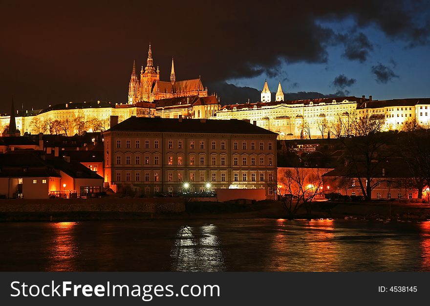 The magnificent Prague Castle at night along the River Vltava