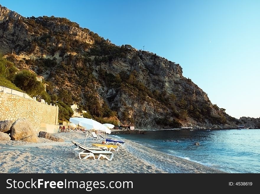 Photo of pebbly beach near a resort on the Mediterranean sea. Photo of pebbly beach near a resort on the Mediterranean sea