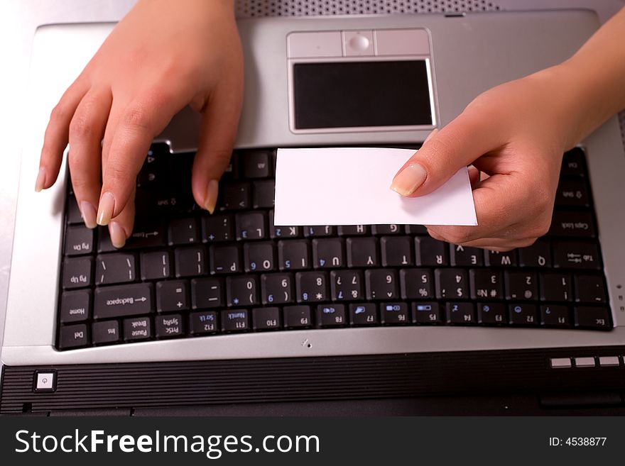 Young woman's hands with computer keybord and business card