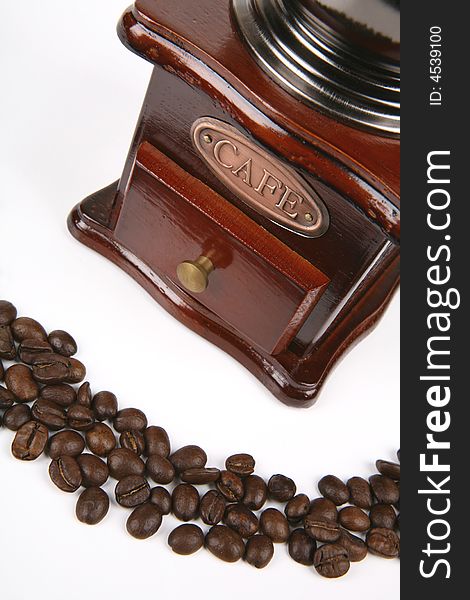 Row of brown coffee beans with wooden grinder. Row of brown coffee beans with wooden grinder