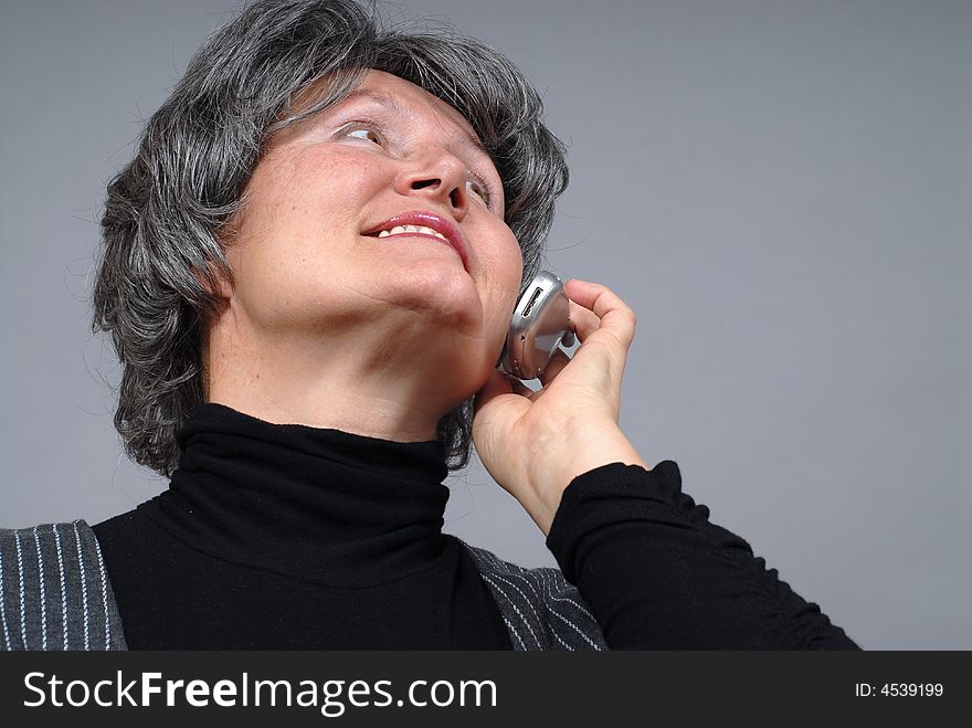 Low angle view of a senior woman talking on a cell phone. Low angle view of a senior woman talking on a cell phone