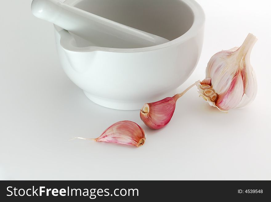 Pestel and Mortar with Garlic bulb and cloves isolated on white. Pestel and Mortar with Garlic bulb and cloves isolated on white