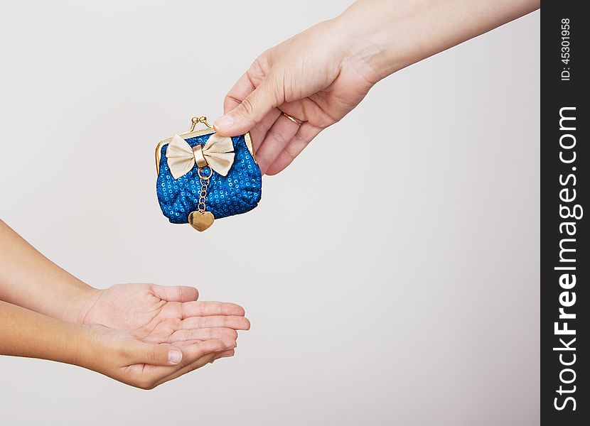 Hands of mother gives the purse to a little girl