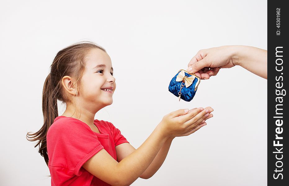 Mother gives the purse to a little girl at home