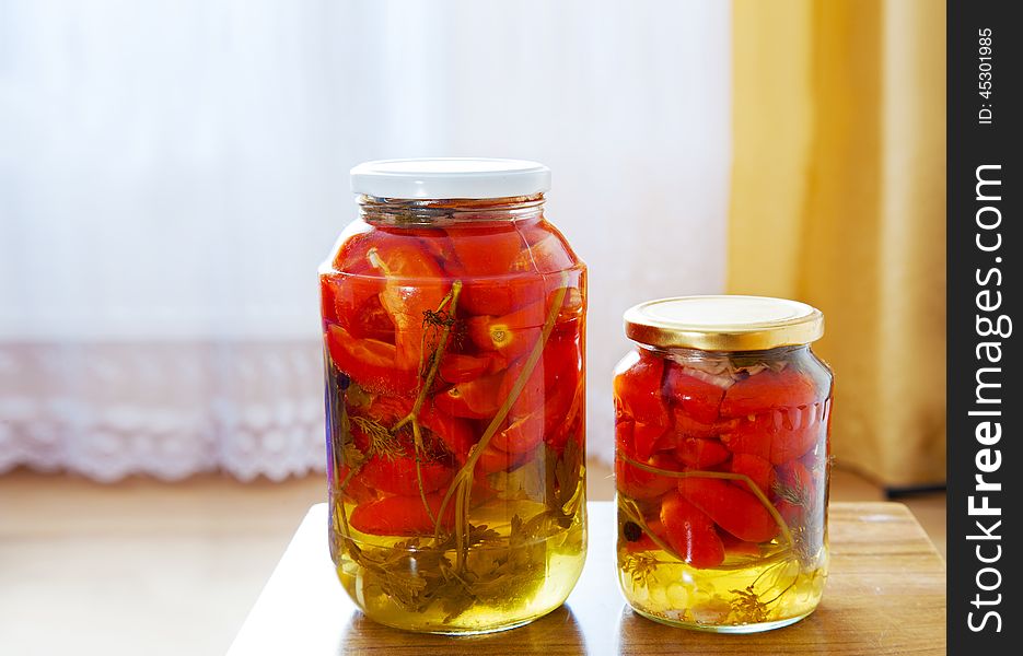 Two glass jars with marinated tomatoes homemade on the table