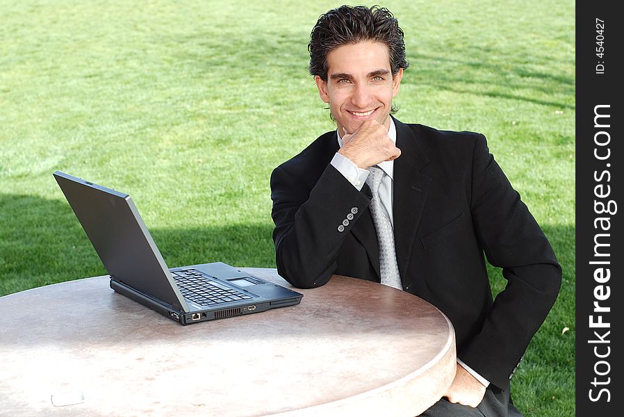 Confident and successful young adult businessman working on his laptop computer. Confident and successful young adult businessman working on his laptop computer