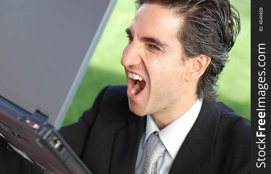 Business is very angry and screaming at his laptop. Business is very angry and screaming at his laptop