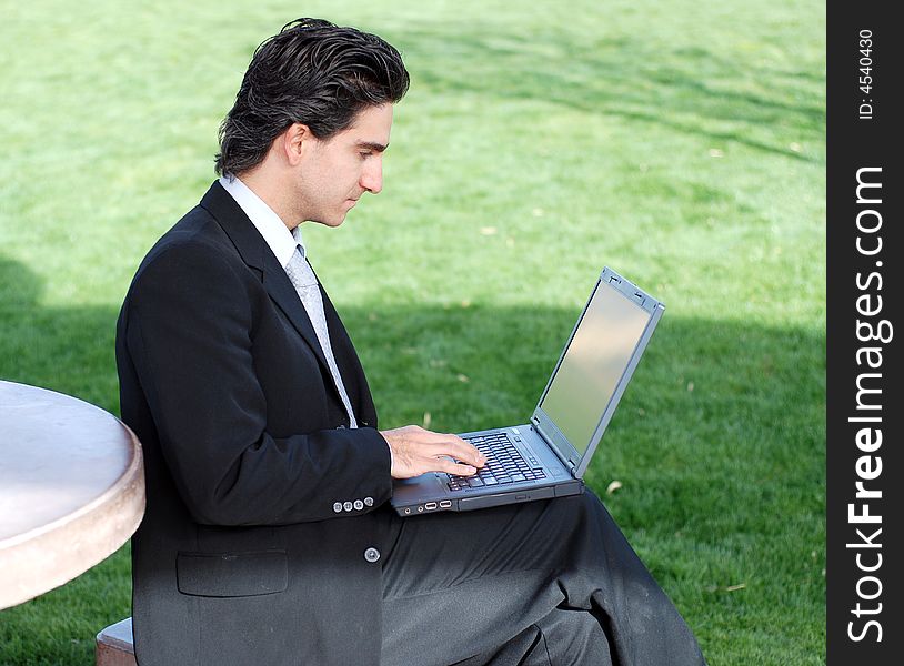 Confident and successful young adult businessman working on his laptop computer