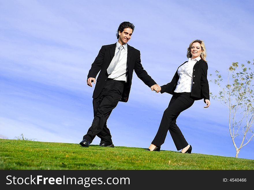 Portrait of a confident and successful business partners running in the field. Portrait of a confident and successful business partners running in the field