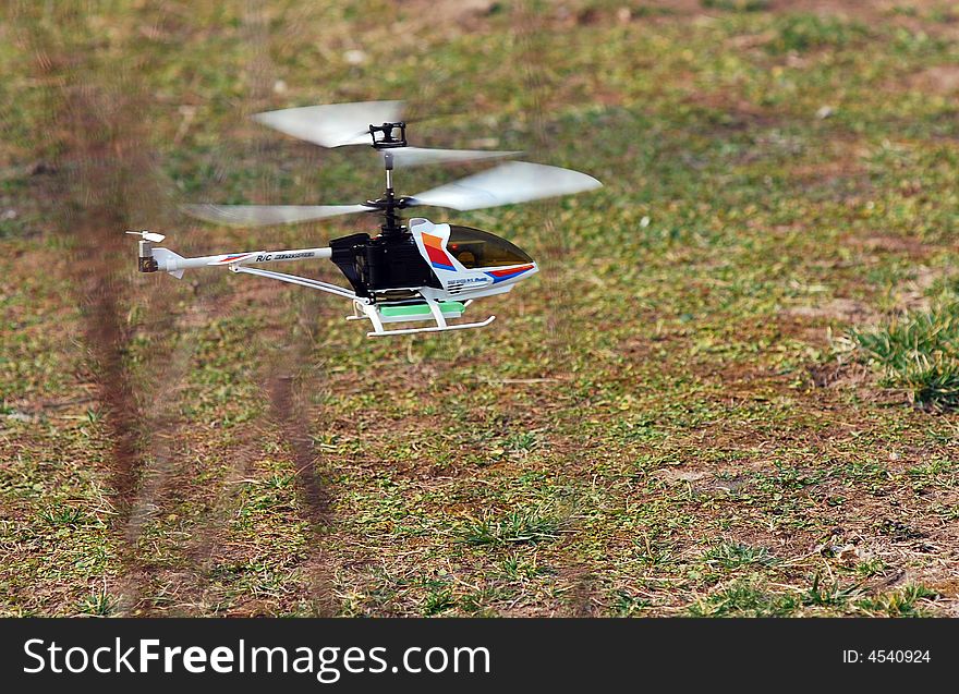 Toy helicopter flying by remote control, with wings go round and round.