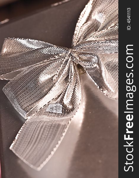 Macro of a silver bow on a box