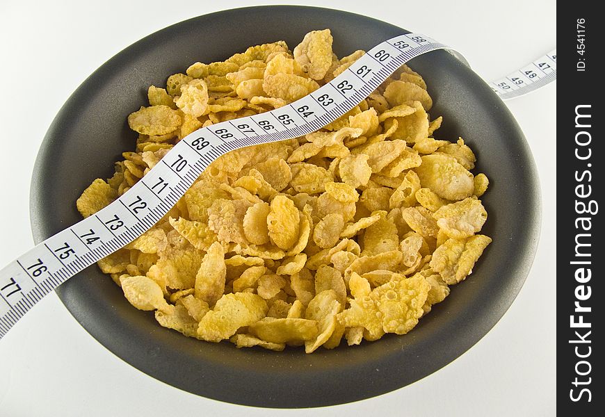 Healthy flakes with measure on black plate. Healthy flakes with measure on black plate
