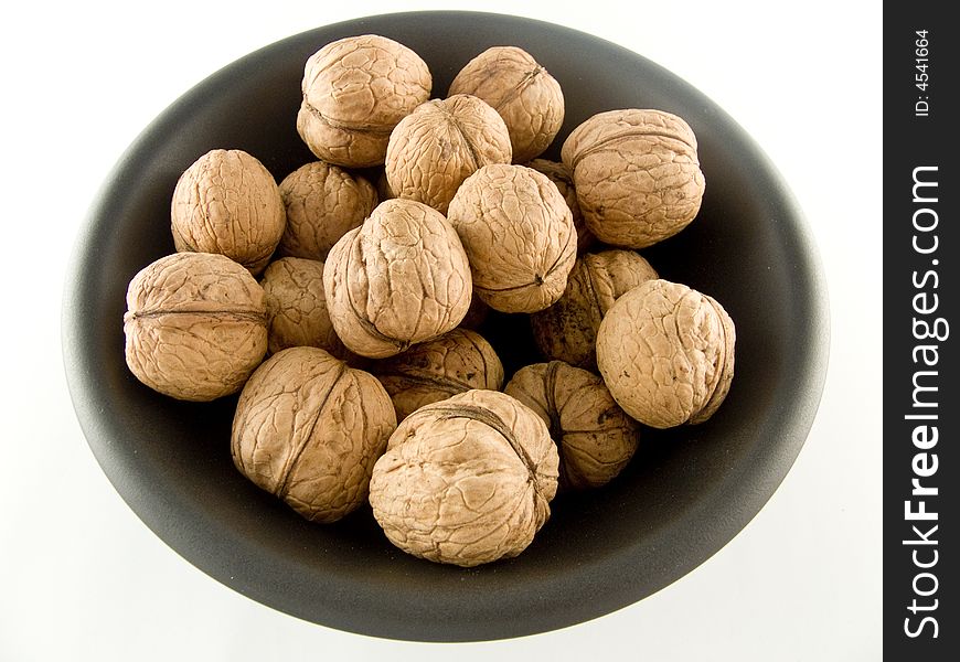 Walnuts on black plate isolated on white