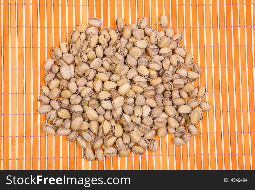 A pile of pistachios on bamboo table-cloth