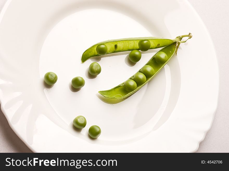 Vegetable theme: pea pod on the white plate