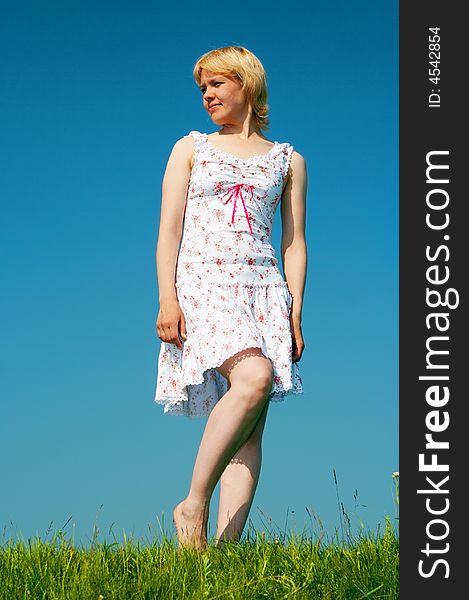 Woman stand on green grass under blue sky