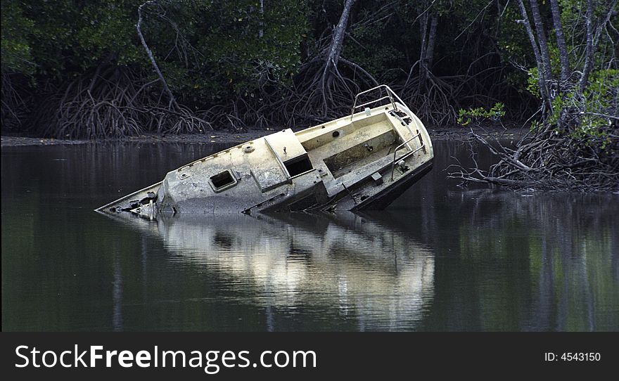 A pleasure boat sunk along the river bank. A pleasure boat sunk along the river bank.