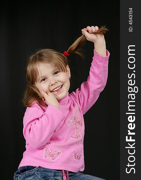 Child keeps hairs and smiles, black background