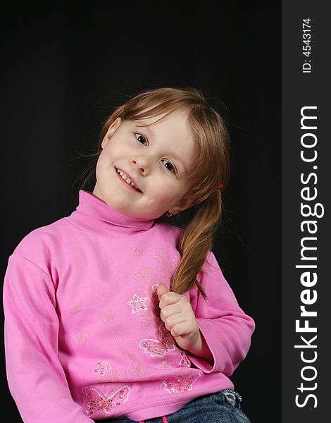 Child keeps hairs and smiles, black background