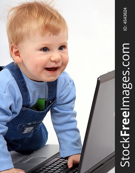 The happy dressed child look at the screen laptop. The happy dressed child look at the screen laptop