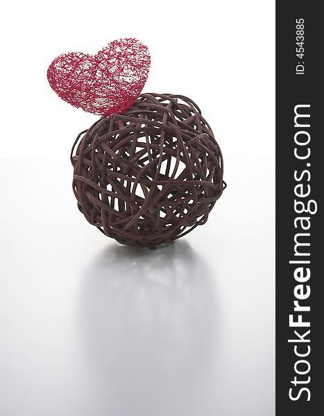 Wicker ball with a red heart made of artificial fiber