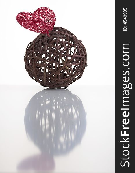 Wicker ball with a red heart made of artificial fiber