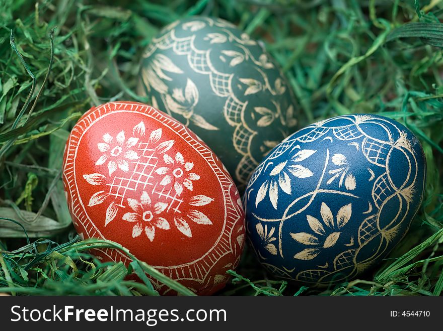 Three handmade easter eggs on the green hay. Selective focus, shallow depth of field. Three handmade easter eggs on the green hay. Selective focus, shallow depth of field.