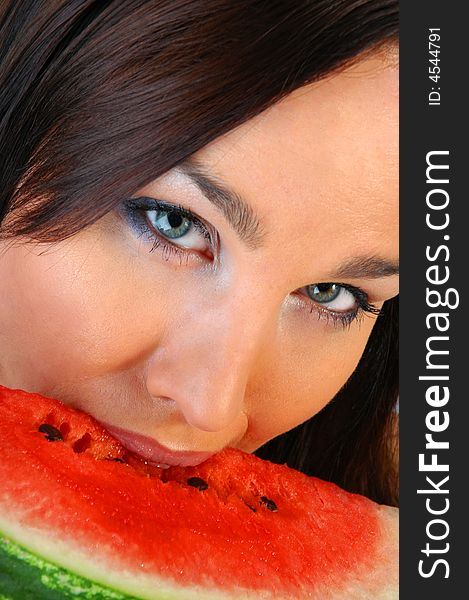 Close up of a beautiful brunette eating a melon