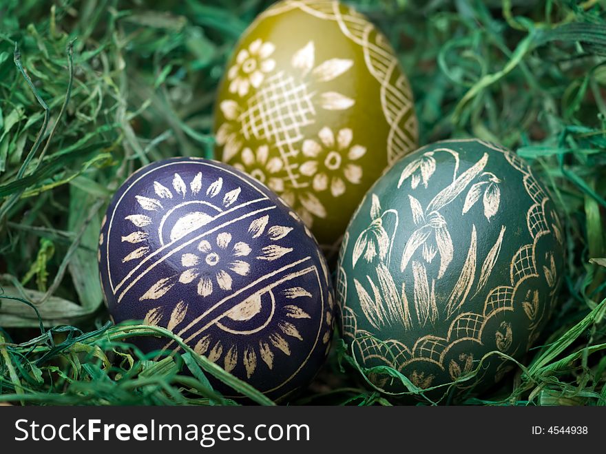 Three handmade easter eggs on the green hay. Selective focus, shallow depth of field. Three handmade easter eggs on the green hay. Selective focus, shallow depth of field.
