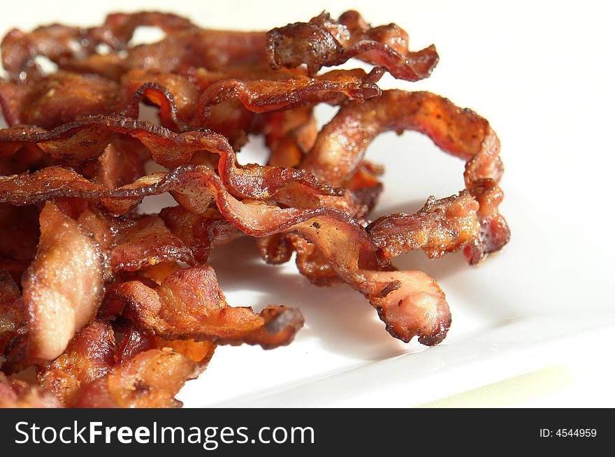 Plate of crisp bacon isolated on a white background. Plate of crisp bacon isolated on a white background