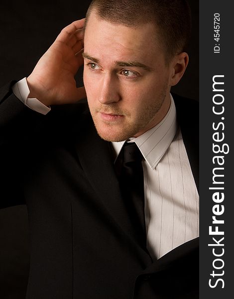 Portrait of a young businessman on black background