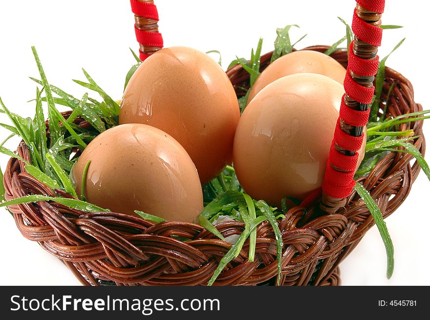 Close-up of four Easter eggs in basket with grass