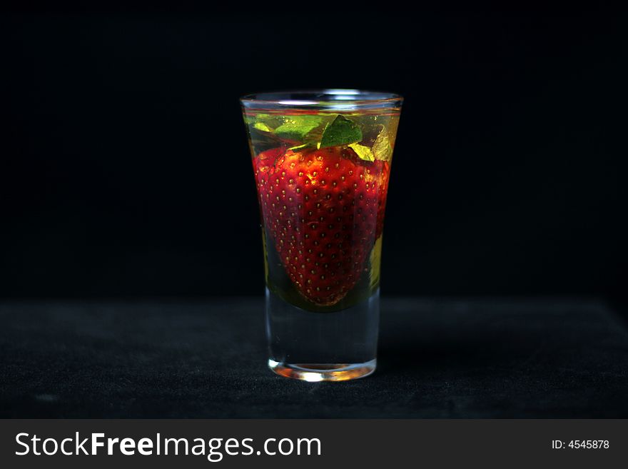 Honey soaked strawberry in glass on dark background. Honey soaked strawberry in glass on dark background.