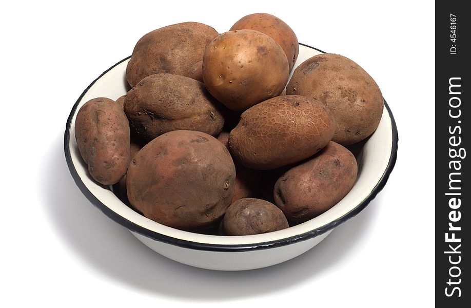 Bowl of raw organic potatoes isolated on white background