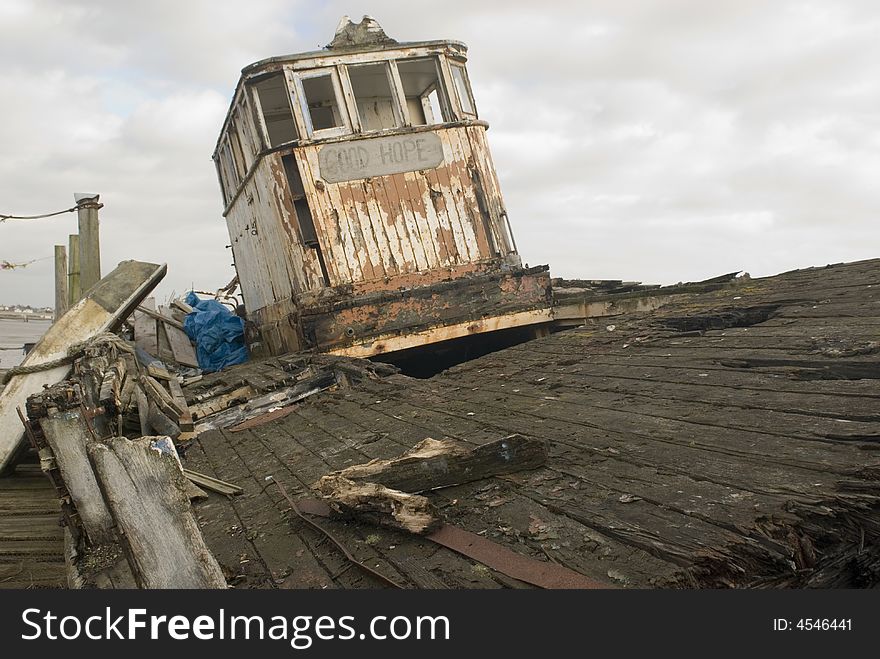 Derelict boat shot along broken deck with a white sky background