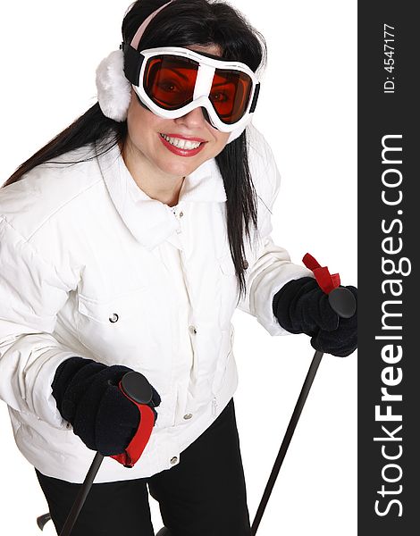 Female skier in white parka, black ski pants wearing ear muffs and ski goggles