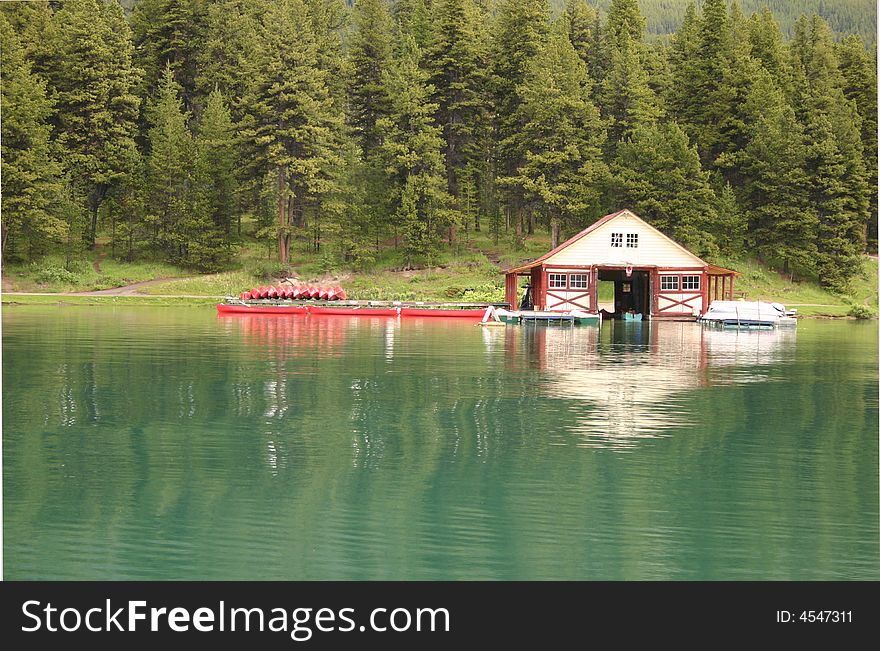 An old boat house reflected in tranguil blue green water