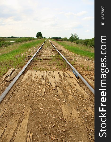 Railroad tracks stretching accross the prairies into the big blue sky. Railroad tracks stretching accross the prairies into the big blue sky