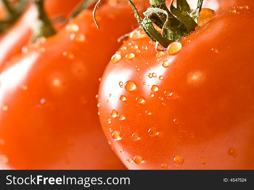 Fresh red ripe tomatoes with water drops shot with a macro lens. Fresh red ripe tomatoes with water drops shot with a macro lens