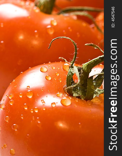 Fresh red ripe tomatoes with water drops shot with a macro lens. Fresh red ripe tomatoes with water drops shot with a macro lens