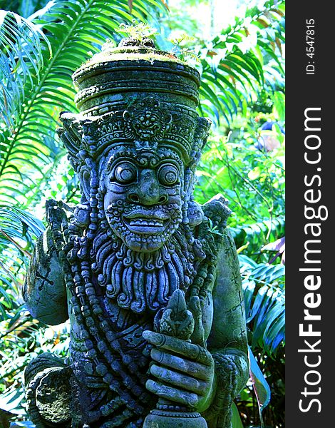 Religious stone statue in tropical garden. Religious stone statue in tropical garden.