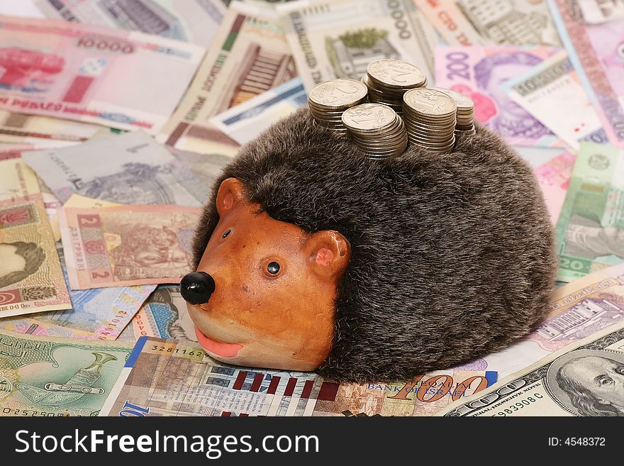 Hedgehog-coin box on a background of denominations